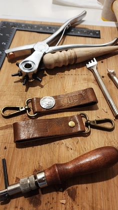 various tools are laid out on a cutting board, including scissors and leather sheaths