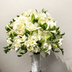 a bouquet of white flowers in a silver vase