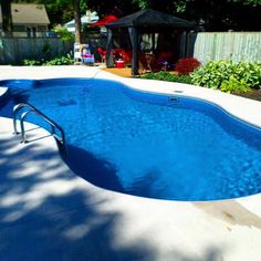 an empty swimming pool in the middle of a backyard