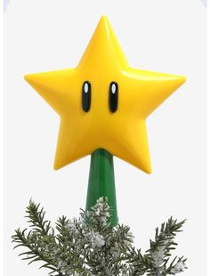 a yellow star on top of a green pole next to snow covered plants and branches