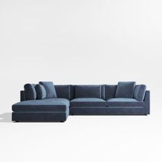 a blue sectional couch sitting on top of a white floor