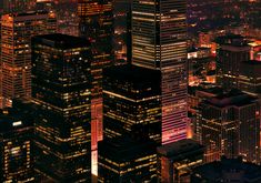 the city lights shine brightly at night in this aerial view from above, as well as skyscrapers