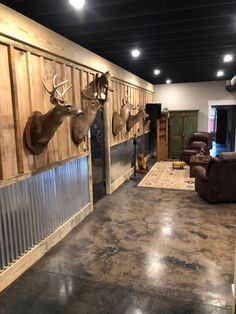 a living room filled with furniture and mounted deer heads