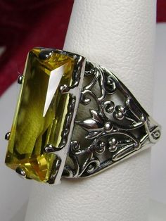 Simulated Yellow Citrine Ring Baguette Design #32 Custom Inspired by the intricate Victorian designs of the late 1800s, I now offer this gorgeous filigree Antique reproduction in sterling silver. The lovely ring is set with a flawless 7ct yellow citrine gemstone. The baguette rectangle-cut simulated yellow citrine is 18mm long by 9mm wide. The ring is 8mm of the finger. The inside of the band is marked 925 for sterling. Notice the intricate and floral design of the silver filigree setting and band. This is an exquisite rendition of an antique filigree ring.... and is ready to wear. A white ring gift-box is included. Feel free to ask questions and thanks for looking at my listings. Suggested retail $169.00+ *CUSTOM Handling Time: Please allow 15 business days to create your custom beauty* S Silver Leaf Art, Yellow Citrine Ring, Art Deco Filigree, Yellow Gems, Yellow Rings, Filigree Jewelry, Yellow Gemstones, Vintage Inspired Jewelry, Vintage Style Jewellery