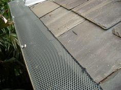 a metal grate on the side of a roof that is missing some shingles