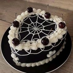 a black and white cake with cherries on top