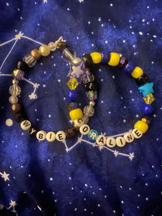 two beaded bracelets with words written on them and stars in the night sky