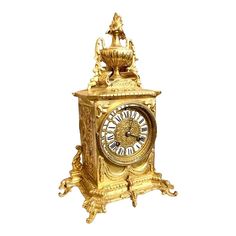 an ornate gold clock is shown against a white background