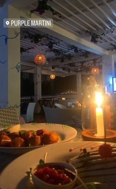 two plates of food on a table with a lit candle