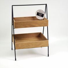 a three tiered wooden shelf with an alarm clock on top