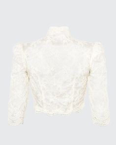 Our Bolero is a cropped scoop top with a mandarine neckline featuring three-quarter, high fitted sleeves. The Bolero is made with embroidered mesh lace and trimmed with an Alençon lace scallop trim. Embroidered mesh lace trimmed with Point d'Alençon Three-quarter sleeves Hook-and-eye closures center front Hand wash and flat dry or dry clean Each piece is made to order and handcrafted in our atelier. Fitted Cropped Blouse With Lace Top, Fitted Cropped Lace Top Blouse, Fitted Lace Patchwork Crop Top, Fitted Cropped Crop Top With Lace Patchwork, Fitted Crop Top With Lace Patchwork, Fitted Crop Top With Lace Sleeves, Fitted Lace Top Cropped Blouse, Elegant Long Sleeve Lace Crop Top, Cropped Lace Trim Top For Party