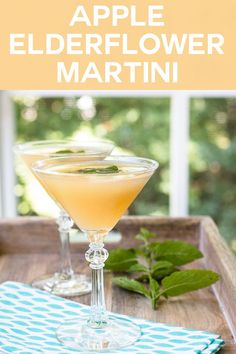 an apple elderflower martini in a coupe glass with mint garnish on the rim