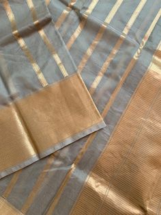 A very unique and stylish pure silk organza benarasi in a gorgeous gray shade with horizontal gold stripes. This is a very different benarasi, especially if you are looking to take a break from traditional sarees. The soft gold and gray look stunning together. The horizontal stripes give a modern look to the six yards. The fabric is extremely good quality silk organza. Saree is Silk Mark Certified. What is Kora Silk? Kora silk is untreated or un-dyed silk primarily made out of twisting only silk Banarasi Sari, Pastel Grey, Jamdani Saree, Dyed Silk, Organza Saree, Silk Yarn, Traditional Sarees, Silk Organza, Silk Dyeing