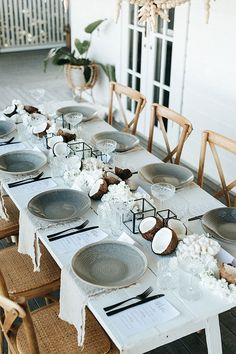 the table is set with plates and place settings for an outdoor dinner party or special event