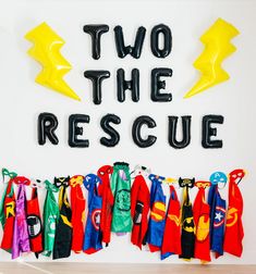 two the rescue balloons and capes are hanging on a wall next to each other