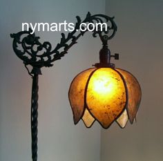 a lamp hanging from the side of a wall next to a light fixture with a flower design on it