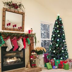 a decorated christmas tree sitting next to a fire place