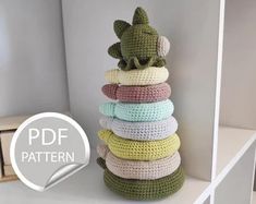 a stack of crocheted pillows sitting on top of a white shelf in a room