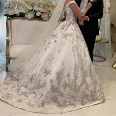 a bride and groom posing for a photo in front of a floral arrangement at their wedding