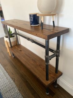 a wooden shelf with pipes and a vase on top