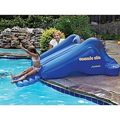 a girl is jumping off an inflatable slide into the pool