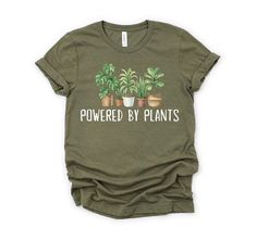 Powered by Plants Shirt, Gardening Shirt, Plant Lover Shirt, Vegetarian Shirt, Gift for Gardener, Retro Plants Shirt, Gardening Tshirt How to order: 1. Select your t-shirt size. 2. Choose your favorite t-shirt color(s). 3. Select quantity from the drop-down menu. 4. Add item(s) to your cart. 5. Choose your payment method. 6. Place your order. Unisex T-Shirt: * 100% cotton (heather colors have polyester) * Fabric weight: 4.5 oz/y² (153 g/m²) * Pre-shrunk for extra durability * Shoulder-to-shoulder placement * Quarter-turned to avoid crease down the center Size:  * We have S to 3XL sizes available (Size chart in Photos) * This is a Unixes T-shirt (compatible for men and women) Wash/Care Instruction: * Turn inside out. * Machine cold wash. * Do not bleach/dry clean. * Do not iron directly on Green Relaxed Fit Shirt With Plant Print, Relaxed Fit Green Shirt With Plant Print, Green Shirt With Plants Print And Relaxed Fit, Green Shirt With Plant Print And Relaxed Fit, Green Relaxed Fit T-shirt With Plant Detail, Spring Green Tops With Plant Details, Green Tops With Plant Print For Gardening, Green Plant Print Tops For Gardening, Green T-shirt With Plant Print For Gardening