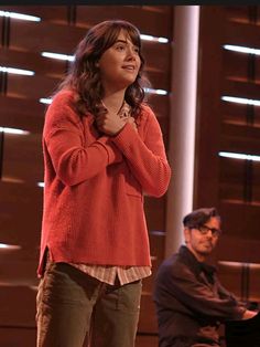 a woman standing in front of a piano