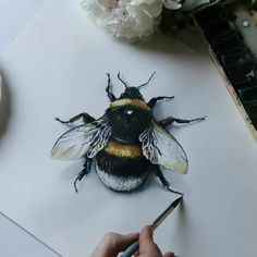 a drawing of a bee on top of a piece of paper next to some flowers