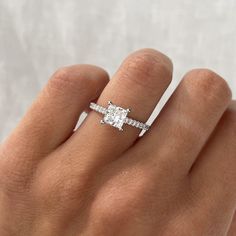 a woman's hand with a diamond ring on top of her finger and an engagement band