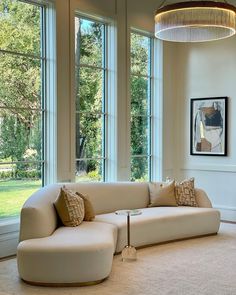 a living room filled with lots of windows next to a white couch and coffee table