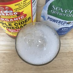 a glass filled with ice and liquid next to two bottles of powerade on a wooden table