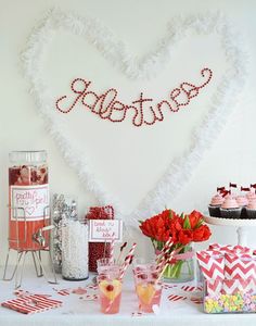 a valentine's day dessert table with cupcakes and candy