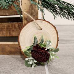 a piece of wood with a flower on it and some greenery hanging from the side