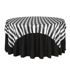 a black and white striped table cloth on top of a round table with an oval cover