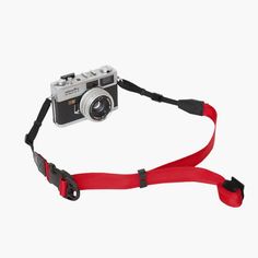 a camera with a red strap attached to it