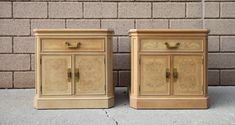 two nightstands sitting next to each other on the ground near a brick wall,