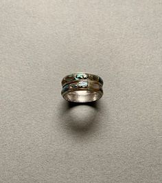 This gorgeous ring features inlaid abalone stones set in sterling silver. It is fairly old, and the inside of the band has some natural tarnishing that I could not remove, but it does not affect the appearance of the ring. It is not marked and is size 7.25. Sterling Silver Inlay Ring, Silver Patina Jewelry For Weddings, Silver Stackable Turquoise Ring For Anniversary, Green Inlay Rings For Anniversary, Green Anniversary Rings With Inlay, Anniversary Green Inlay Rings, Sterling Silver Patina Ring, Sterling Silver Inlay Ring For Anniversary, Round Patina Rings For Anniversary