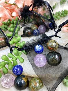 several marbles are sitting in organ bags on a table with flowers and greenery