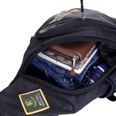 an open black backpack filled with books and other items in it's pocket on a white background