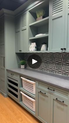 a kitchen with gray cabinets and white baskets