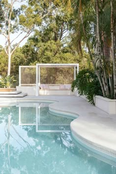 an empty swimming pool surrounded by palm trees