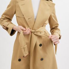 A modern update to a timeless silhouette our lightweight cotton-blend trench is designed with a relaxed fit for easy comfortable wear. Detailed with leather belted cuffs in a nod to our heritage the double-breasted topper is finished with shoulder epaulettes an adjustable belt at the waist and a back vent for ease of movement. | Coach Trench Coat - Women's Size XL - Khaki Elegant Cotton Outerwear With Belted Cuffs, Timeless Gabardine Outerwear For Spring, Timeless Spring Outerwear With Double Button Closure, Classic Double-breasted Outerwear With Belted Cuffs, Classic Fall Outerwear With Self Belt, Classic Outerwear With Belted Cuffs, Classic Outerwear With Self Belt, Classic Gabardine Belted Outerwear, Timeless Belted Outerwear For Work