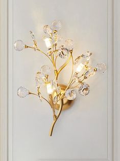 a wall mounted light that is on the side of a white door with glass flowers