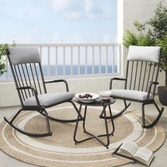 two rocking chairs sitting on top of a rug next to a table with fruit on it