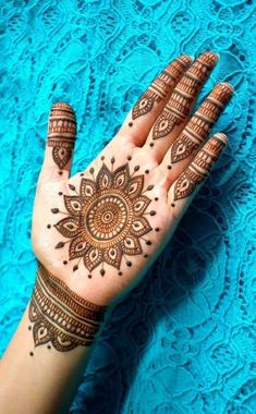 a woman's hand with henna tattoos on it