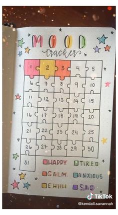 an open notebook with a puzzle on the page and words written in it that read mood tracker