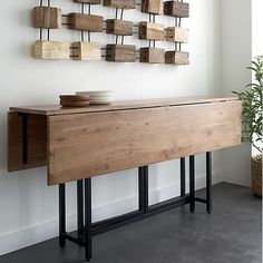 a wooden table sitting in front of a white wall