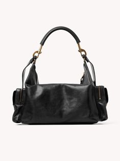 Chloé's Large Camera bag is crafted from natural shiny buffalo leather. Its multiple pockets are embellished with revamped buckles from the iconic Paddington bag. Carry the Camera bag in the hand, on the shoulder or cross-body with the handles or strap. Product Details Designer ID: CHC24AS532N83001 Color: Black Composition: Main material: Buffalo leather; Flap lining: Buffalo leather; Main lining: 54% Cotton, 46% Linen Width: 16.9" (43 cm); Height: 7.9" (20 cm); Depth: 8.3" (21 cm); Handle drop: Luxury Crossbody Hobo Bag With Gunmetal Hardware, Luxury Hobo Bag With Gunmetal Hardware Crossbody, Luxury Hobo Shoulder Bag With Gunmetal Hardware, Luxury Hobo Bag With Metal Hardware And Double Handle, Luxury Shoulder Bag With Gunmetal Hardware And Double Handle, Luxury Hobo Bag With Gunmetal Hardware In Tote Shape, Luxury Satchel With Gunmetal Hardware, Luxury Hobo Bag With Gunmetal Hardware, Designer Shoulder Bag With Palladium Hardware And Double Handle