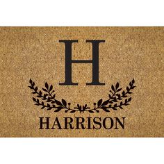 a door mat with the letter h and an image of a laurel wreath on it