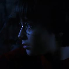 a close up of a person wearing glasses in the dark